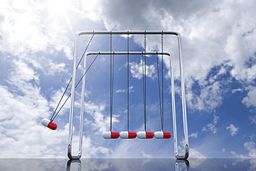 Newtons cradle with capsules