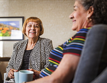 Smiling senior women holding cups