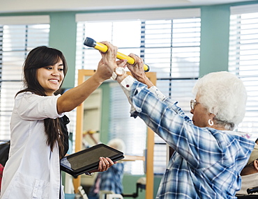 Smiling doctor helping senior woman hold pole