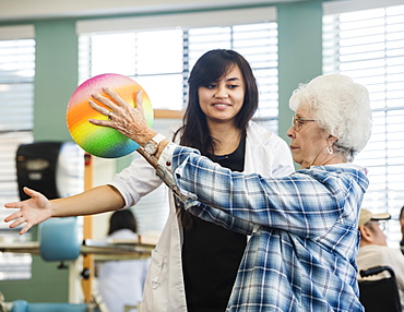 Senior woman holding ball at rehabilitation center