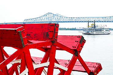 Mill wheel with Crescent City Connection bridge in distance in New Orleans, USA