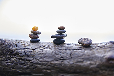 USA, Washington, San Juan County, Orcas Island, Stacks of pebbles on log