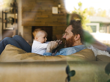 Father playing with baby son (2-3 months)