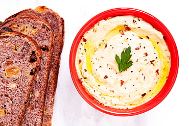 Overhead view of bowl of hummus and slices of bread