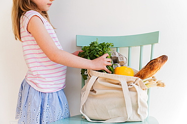 Girl unpacking products from reusable bag