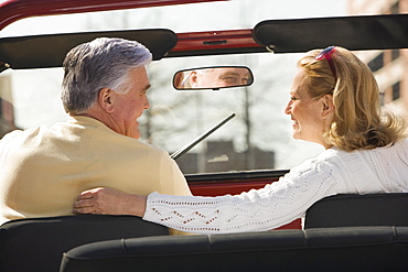 Senior couple sitting in jeep