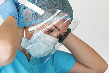 Nurse putting on face shield