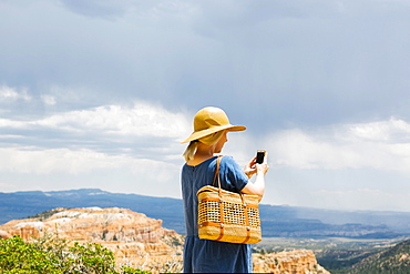 USA, Utah, Bryce Canyon, Woman photographing canyon with smart phone