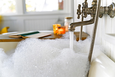 Bubble bath with book and candles