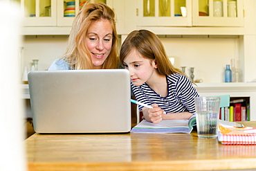 Mother and daughter looking at laptop