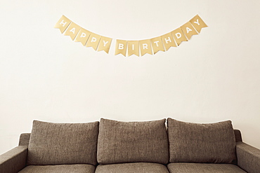 Happy birthday wishes on wall above sofa