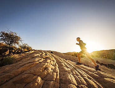 USA, Utah, St. George, Man running in rocky landscape