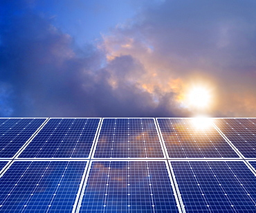 Sun and clouds reflecting in solar panel