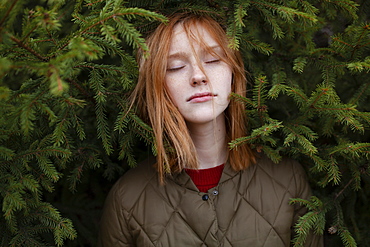 Portrait of young woman in foliage