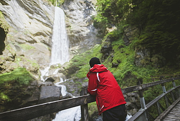 Switzerland, Man looking at Berschner waterfall in mountains