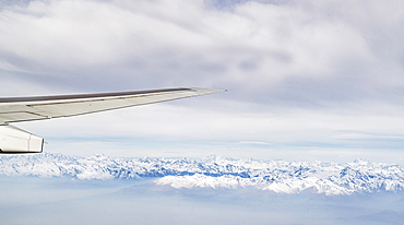 Switzerland, Canton Wallis, Airplane wing over snowy mountains