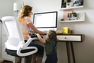 Girl (2-3) interrupting mother working from home