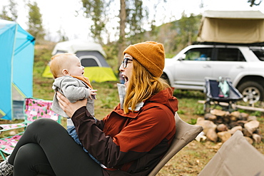 USA, Utah, Uninta Wasatch Cache National Forest, Mother holding son (6-11 months) on campsite