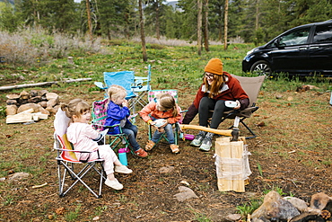 USA, Utah, Uninta Wasatch Cache National Forest, Mother with daughters (2-3, 6-7) eating breakfast during camping