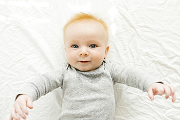 Portrait of baby boy lying on bed