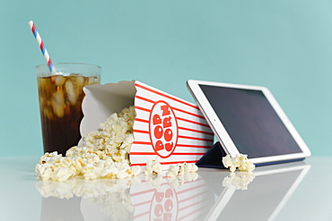 Studio shot of popcorn with digital tablet and soda