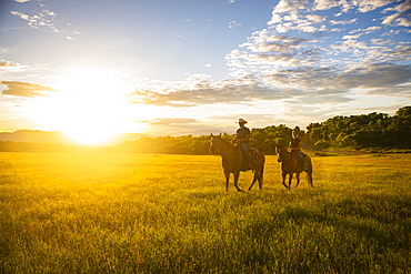 USA, Utah, Salem, Father and daughter (14-15) riding horses at sunset