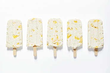 Rice and mango popsicle sticks on white background