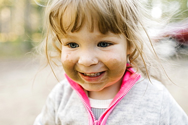 Close-up of smiling girl (2-3) with sand on face, Wasatch Cache National Forest