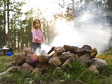 Girl (4-5) roasting marshmallow above campfire, Wasatch Cache National Forest