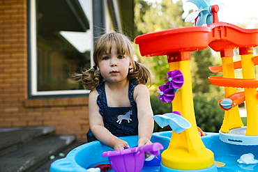 Portrait of toddler girl (2-3) playing with water in garden