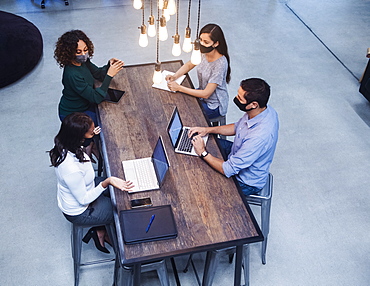 People in face masks having meeting in office