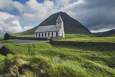 Denmark, Faroe Islands, Vidareidi, Green landscape with rural church and mountain