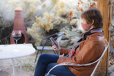 Woman wearing protective face mask sitting on bench