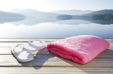 USA, New York, North Elba, Lake Placid, Sandals and towel on dock