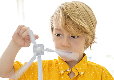 Boy (6-7) playing with wind turbine model