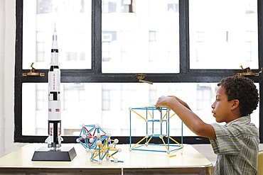 Mixed race boy building geometric shape