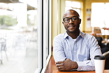 Black man having cup of coffee in cafe