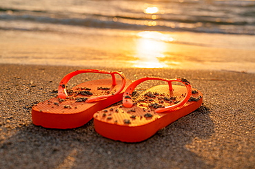 United States, Florida, Boca Raton, Flip flops on beach at sunset