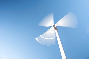 Low angle view of wind turbine against blue sky