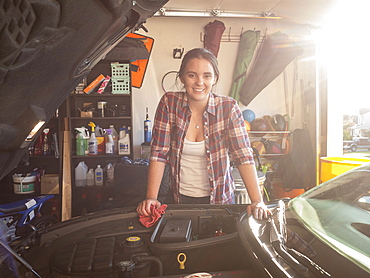 Woman fixing car in garage