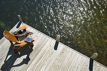 United States, New York State, Lake Placid, Overhead view of Adirondack chair book and blanket on wooden pier