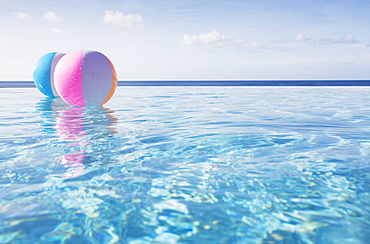 Beach balls floating on water in infinity pool