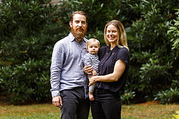 Portrait of young family, outdoors, smiling