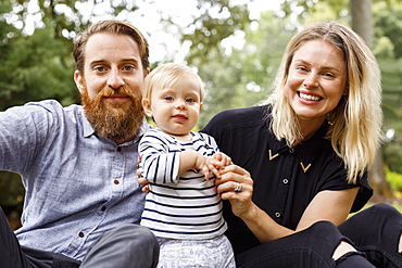 Portrait of young family, outdoors, smiling