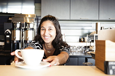 Coffee shop barista serving coffee