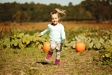 Girl running in pumpkin field