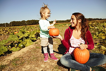 Mother and daughter in pumpkin field