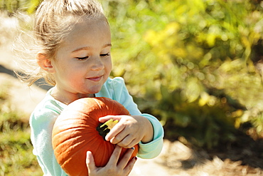 Girl carrying pumpkin