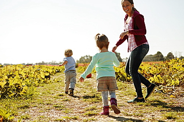 Mother with two children in pumpkin field