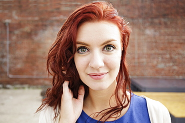 Portrait of young woman with long red hair, close-up